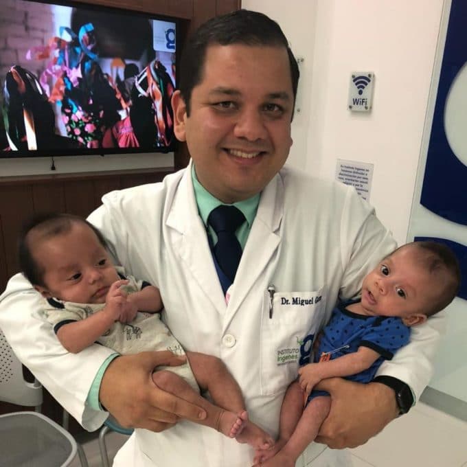 Dr. Miguel Garza cargando a dos estrellitas que ayudó a traer al mundo