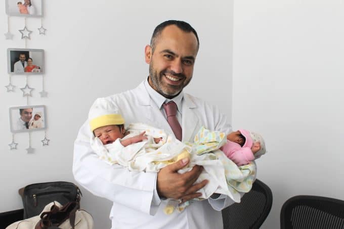 Dr. Briones cargando a dos bebés nacidos vía fecundación in vitro