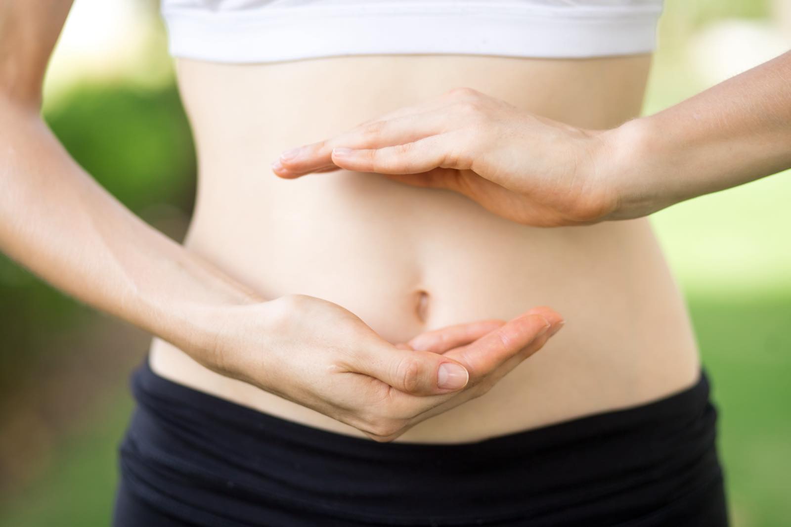 Hands forming a circle around the abdomen, referring to gut health