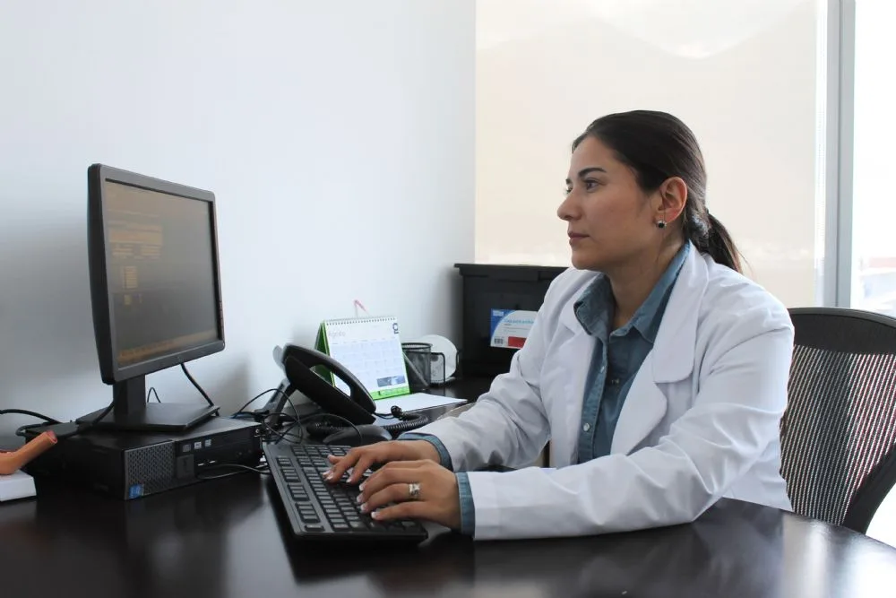 Professional smiling in her office, with balance between career and family project