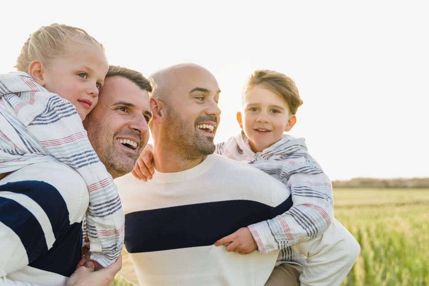 Couple of dads embracing their newborn baby achieved through surrogacy